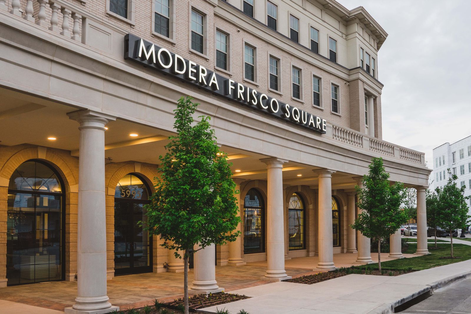 An apartment building with a sign that says "Modera Frisco Square."